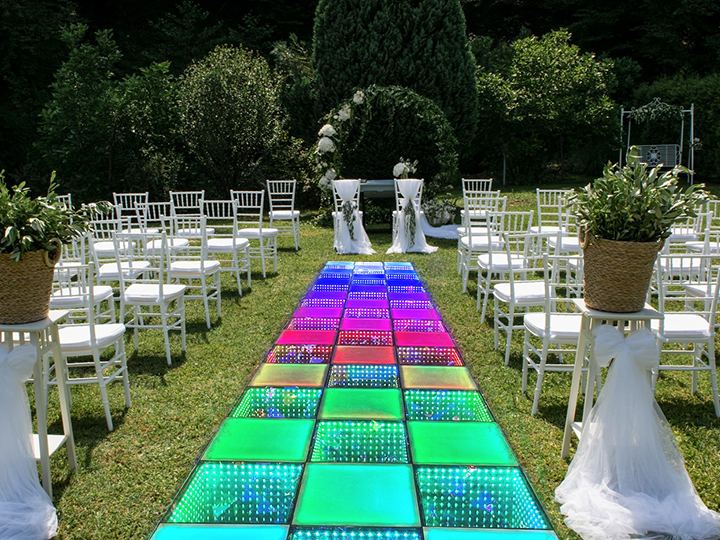 An elegant outside wedding dance floor setup on a grassy lawn