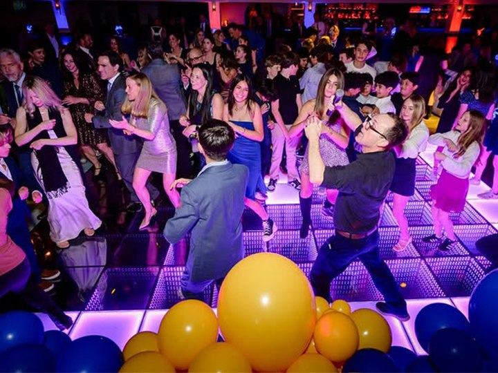 Dancers enjoy a futuristic club on a vibrant LED dance floor
