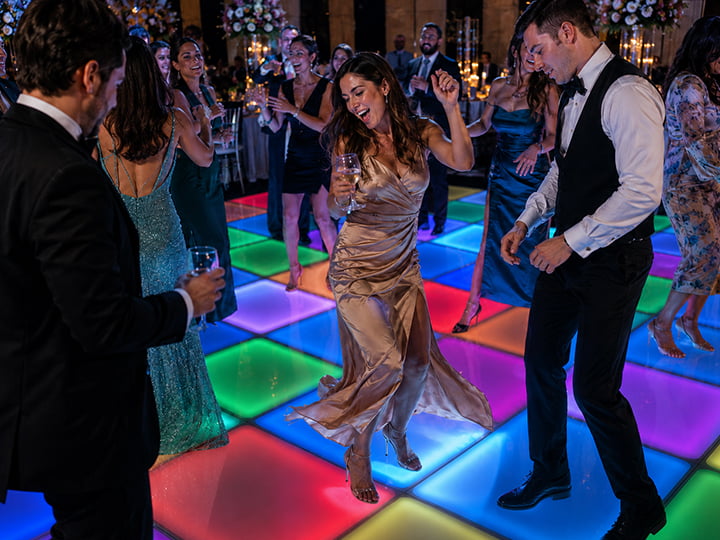 Happy wedding guests dancing on dynamic light up floor